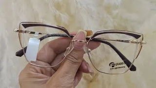 Montura metálica dorada estilo ojo de gato con ceja translúcida y acentos berenjena, para dama